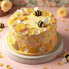 there is a cake with yellow flowers and bees on the top, along with other decorations