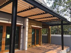 an outdoor covered patio area with sliding glass doors and wood slats on the roof