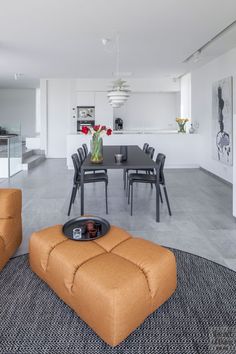 a living room filled with furniture next to a dining room table and kitchen counter top