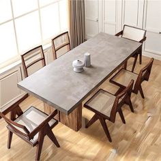 a dining table with chairs around it and a vase on the table next to it