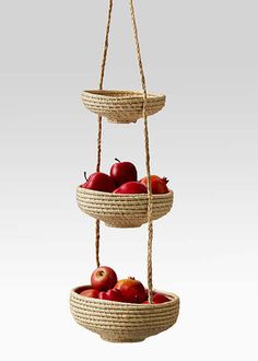 three baskets filled with apples hanging from ropes