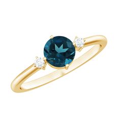 a gold ring with an oval blue topazte and two diamonds on the side