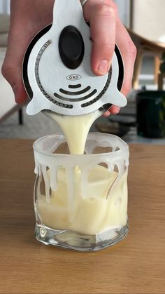 a person pouring milk into a blender