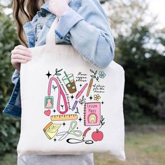 a woman holding a tote bag with sewing related items on it