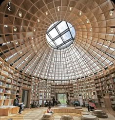 the inside of a library with lots of bookshelves and people sitting at tables