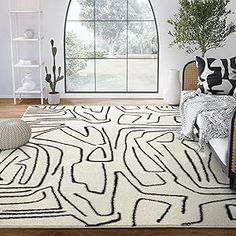 a large white rug with black and white designs on it in front of a window