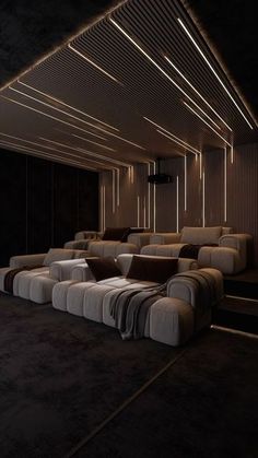 an empty theater room with couches and lights on the ceiling is shown in this image