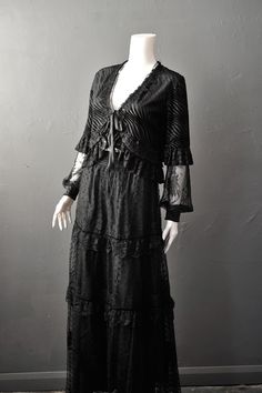 Haunt the dark corridors of your gothic mansion in our 'Doleful Devoré' long sleeve velvet shrug, as you rue the day your true love died. Made of a lightweight black devoré velvet in a wavey stripe pattern, and trimmed with a variety of soft ruffled lace and lace motifs, this fastens at the front with satin ribbon ties, and has sheer lace bishop sleeves with satin cuffs, finished with ribbon bows. Great for layering for a romantic gothic outfit, or as a light cover up for summer nights! Polyeste Stevie Nicks Costume, Velvet Shrug, Velvet Bolero, Gothic Mansion, Goth Chic, Gothic Outfit, Gothic Lingerie, Lace Motifs, Black Velvet Leggings