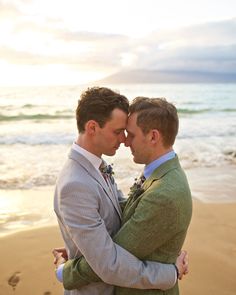 two men hugging each other on the beach