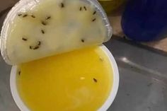 a bowl filled with yellow liquid next to a plastic container