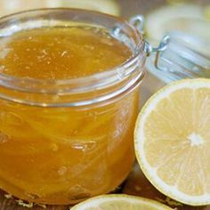 a glass jar filled with liquid next to sliced lemons