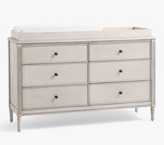 a white dresser with drawers and a baby crib in the top right hand corner