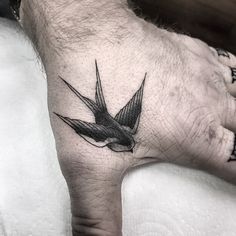 a hand with a bird tattoo on it