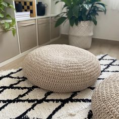 two crocheted round poufles on a rug in front of a plant