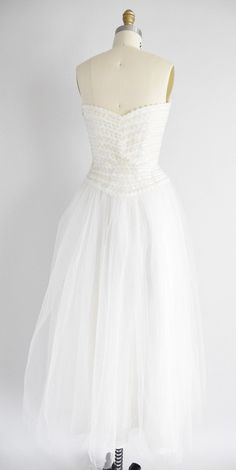 "Vintage 1950s brilliant white tulle dress. Sweetheart bust with iridescent sequins. Double tulle layered skirt. Strapless with boning bodice. Side metal zipper closure. State of garment | excellent Measurements ✂--- best fit | extra small bust | 34\" center bust to waist | 10 \" waist | 24.5 - 25\" hips | free total length (shoulder to hem) | 50\" tag | none present ★★Visit The Shop★★ http://www.etsy.com/shop/seaofvintage ➸ Find the shop on Twitter & Instagram for peekaboo sales & other Fitted Vintage Tulle Dress, Vintage Fitted Tulle Dress, Fitted Vintage Tulle Skirt Dress, Vintage White Tulle Dress, Vintage White Dress For Debutante Ball, White Ball Gown For Vintage Events, Tulle Layered Skirt, White Tulle Dress, White Tulle