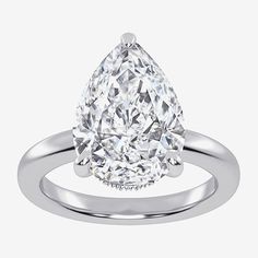 a pear shaped diamond engagement ring on a white background, with the center stone set in 18k white gold