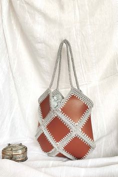 %100 hand made small size brown baklava diagonal shape crochet bag with vegan leather and chain hanger. The bag made with high quality yarns and leather This special bag is lined. Perfect for special days, city adventures and shopping etc.  This crochet bag is the perfect accessory for your spring and summer. Summer is so close and the sun is shining everywhere, it's time for summer fashion :) This bag can be used for anything. A nice gift idea  Measures: Height: 30 cm, Width : 30 cm, Handles : 50 cm Height: 11,80 inch, Width: 11,80 cm,  Handles : 19,70 cm Materials:  Paper yarn and vegan leather Please feel free to contact with us if you have any question. Brown Leather Crochet Bag With Handles, Brown Crochet Shoulder Bag For Shopping, Brown Square Crochet Bag For Shopping, Square Brown Crochet Shopping Bag, Brown Square Crochet Shopping Bag, Brown Crochet Tote Bag With Granny Square, Brown Granny Square Crochet Tote Bag, Everyday Brown Crochet Bag With Granny Square, Brown Crochet Bag With Granny Square Design