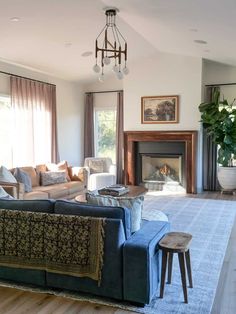 a living room filled with furniture and a fire place in the middle of a room