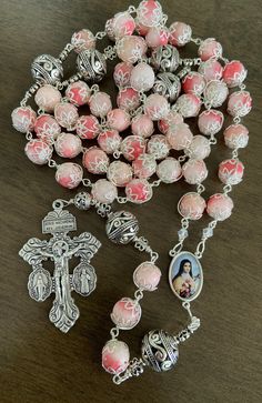 "This beautiful handmade rosary is made with 10mm pink stone,silver plated beads, 2\" Pardon crucifix. Length: 28\" inches long" Handmade Silver Rosary With Crucifix, Pink Spiritual Rosary Bracelet With 8mm Beads, Pink Beaded Spiritual Rosary Bracelet, Pink 8mm Bead Spiritual Rosary Bracelet, Pink 8mm Beads Rosary Bracelet, Pink Spiritual Jewelry With 8mm Beads, Pink Rosary With Miraculous Medal As A Gift, Pink Rosary With 8mm Round Beads, Pink Rosary With 8mm Beads For Gift