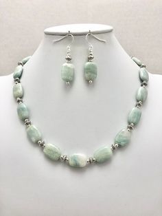 DESCRIPTION:  This beaded necklace features a strand of aquamarine rectangle-shaped beads spaced with tiny round silver pewter beads and tiny silver pewter saucer-shaped beads. I kept the design extremely simple to keep the focus on the aquamarine nuggets. The aquamarine beads are a soft blue color with white inclusions in the stone--it is reminiscent of clouds against a pale blue sky or the white caps on ocean waves! Each bead is so unique and lovely. The tiny silver beads adds a decorative det Elegant Round Bead Amazonite Jewelry, Elegant Amazonite Round Beads Jewelry, Elegant Round Beaded Amazonite Jewelry, Blue Single Strand Amazonite Jewelry, Aquamarine Gemstone Bead Jewelry As Gift, Aquamarine Gemstone Beads Jewelry As Gift, Blue Amazonite Single Strand Jewelry, Blue Amazonite Jewelry With Single Strand, Elegant Rectangular Polished Beads Jewelry