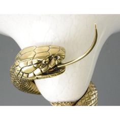 a close up of a lamp with a snake on it's head and arms