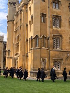 many people are walking in front of an old building