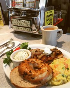 a white plate topped with breakfast foods and a cup of coffee