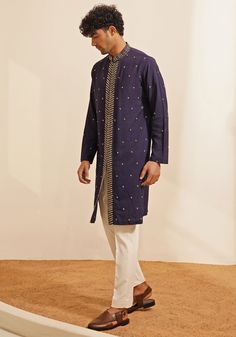 Featuring an elegant Navy Blue Kurta Set, this ensemble includes a button-down kurta designed with a Chinese collar and a hidden placket. The hand-embroidered details on the Kurta add a touch of grace and sophistication. Teamed with elegant white pants, this kurta set combines traditional elegance with contemporary style. Perfect for special occasions like Mehendi or Sangeet. Composition : Chanderi Silk Care: Dry Clean Only and Vacuum Storage This product can be customized for sleeves, length and colour Delivery : 4-6 weeks as the product is hand crafted. Check Size Guide or choose MySize for free customisation (All Sizes above XL can be made at 15% additional cost) For more information and sizes please contact fabiliciousfashion@gmail.com or visit our Copenhagen studio. About the Designer Navy Blue Kurta, Silk Kurta Set, Blue Kurta, Chinese Collar, Vacuum Storage, Indian Wedding Wear, Silk Kurta, Embroidered Details, Kurta Designs