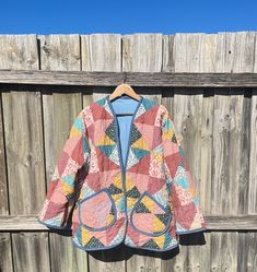 a colorful jacket hanging on a wooden fence