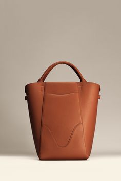 Experience modern simplicity with the Marina Bucket, embodying the dynamic spirit of city-living. Crafted from responsibly sourced Italian top grain leather, this sleek and lightweight bag complements any outfit. It features a central compartment that accommodates up to a 14" laptop, and can be worn as a handbag or shoulder bag. Plus, includes a detachable leather zip pouch for those spontaneous moments on-the-go. Leather Work Bag, Leather Zip Pouch, Sustainable Leather, Laptop Tote, Lightweight Bag, Stylish Shoulder Bag, Leather Bucket Bag, Leather Bucket, Leather Work