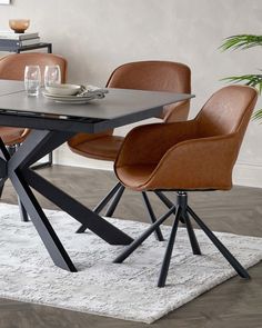 a dining room table with four chairs and a white rug on the floor in front of it