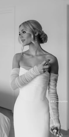 black and white photograph of a woman in a wedding dress with gloves on her arm