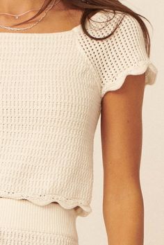 Crochet knit top. Boat neckline. Short raglan sleeves. Scalloped edge detail at sleeves and hem. Sleeveless lining. Cropped length. Fitted silhouette. 100% Cotton. Imported. Designed in LA. Model wears size S. Spring Crochet Trim Knit Top With Crew Neck, Spring Knit Top With Crochet Trim Crew Neck, Spring Crochet Trim Crew Neck Knit Top, Spring Knit Tops With Scalloped Edges, Chic Short Sleeve Crochet Top With Pointelle Knit, Spring Crew Neck Tops With Scalloped Edges, Cropped Crochet Top With Textured Knit, Stretch Cotton Crochet Top With Pointelle Knit, Fitted Cropped Tops With Crochet Trim