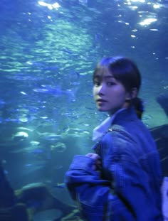 a woman standing in front of an aquarium