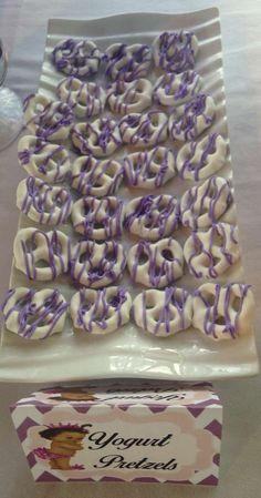 purple and white doughnuts on a plate next to a candy bar