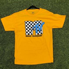 New Without Tags! Bright, Bold And Stylish Retro Mtv Brand Shirt With A Distinctive Checker Pattern Logo. Pit-To-Pit Width: ~ 22 Cuff-To-Shoulder Length: ~ 8 Shoulder Seam To Waist Length: ~ 30 Please Enlarge Pictures For Clear Representation Of Condition. All Sizes Are Approximate, And May Fit Differently From New Items. Please Check Measurements Closely Before Buying! Usually Ships The Next Business Day! Y2k Graphic Print Tops For Fan Merchandise, Yellow Graphic Design Tops For Fan Merchandise, 90s Logo Print Tops For Fan Merchandise, 90s Logo Print Tops For Fans, 90s Style Logo Print Fan Merchandise Tops, 90s Style Logo Print Tops For Fans, 90s Style Tops With Logo Print For Fans, 90s Inspired Yellow Cotton Top, Yellow Cotton Top, 90s Inspired