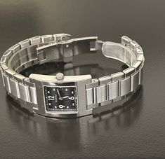 Gucci beautiful women's  6 1/2" silver - black square link timepiece, Swiss made and pre-owned with a new battery, gives precise time, with a wonderful new crystal, and recently serviced by a professional jeweler. Serial number 003683 embossed @ back base and 100% authentic guaranteed. with a protective seal @ back base.  Model 7700L and a 27mm case (the dial is the size of a quarter) Please view my 100% positive reviews it tells my history. with same day secure, fast shipping, Thank you for your consideration. Timeless Silver Square Watch, Silver Rectangular Analog Watch, Silver Watch Accessories With Diamond Hour Markers, Rectangular, Silver Rectangular Watch Accessories With Diamond Hour Markers, Silver Rectangular Metal Watch, Rectangular Silver Metal Watch, Silver Square Watch With Metal Dial, Silver Rectangular Watch Dial With Diamond Hour Markers, Elegant Silver Square Watch