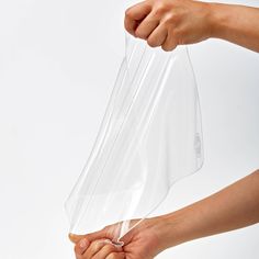 two hands holding a clear plastic bag on top of each other