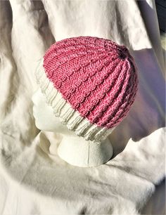 "Ladies' hat is hand knit in 60% Pima cotton and 40% Modal (natural beech wood fiber).  This cap features a white ribbed brim and columns of delicate pink cables which create a lovely textured fabric.    With an 18\" circumference which is VERY stretchy, the cap is designed to fit an average adult head of 18\"-24\".  The colors are bright white and bubblegum pink. This hat was such fun to knit; I love the dainty cables.  The cap is not particularly slouchy, but rather a close fit. The fiber is e Ladies Hat, Chemo Caps, Wood Fiber, Winter Hats For Women, Skull Cap Beanie, Bubblegum Pink, Textured Fabric, Beech Wood, Beanie Hat