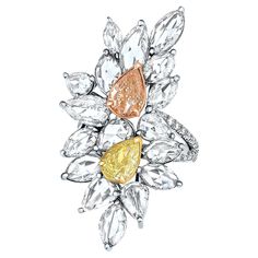 An Exquisite Art Nouveau-Inspired Cocktail Cluster Ring showcasing a mesmerizing fusion of a 1.01 Carat Fancy Yellow Pear-Shaped Diamond, certified by GIA as VS1 in clarity, and a 1.01 Carat Fancy Pink-Brown Diamond, also GIA certified as SI2 in clarity. This stunning creation is adorned with 8 Rose Cut Pear-Shaped Colorless Diamonds, totaling approximately 2.87 carats, along with 11 Rose-Cut Marquise-Shaped Colorless Diamonds, with a combined weight of approximately 4.24 carats. It is gracefully presented within a floral motif setting. Crafted with meticulous precision in lustrous 18K yellow, rose and white gold, this enchanting piece is further enhanced by 0.39 Carats of Colorless Diamonds elegantly pave-set along the shank. Total Diamond Weight: 9.54 carats It’s a beautiful and unique p Diamond Cluster Rings, Diamond Supply, Colorless Diamond, Modern Ring, Brown Diamond, Pear Shaped Diamond, Diamond Cluster Ring, Fancy Color Diamonds, Rough Diamond