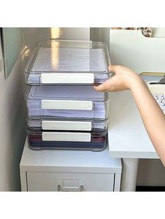 a stack of files sitting on top of a filing cabinet next to a computer keyboard