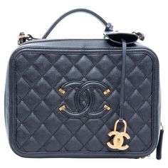 This Chanel CC Filigree Vanity Case is made with diamond quilted caviar leather in black. The bag features gold toned hardware, an embroidered CC at the front face, a gold toned chain interlaced with leather, a single flat leather top handle, and leather interior lining with two interior compartments. Complete with a gold toned CC charm. Chanel bags with the serial number 26XXXXXX are manufactured from 2018-2019. COLOR: Black MATERIAL: Caviar leather ITEM CODE: 26501655 MEASURES: H 7” x L 9” x D Vanity Case Bag, Chanel Vanity, Chanel Store, Front Face, Vanity Case, Black Caviar, Chanel Bags, Diamond Quilt, Leather Items