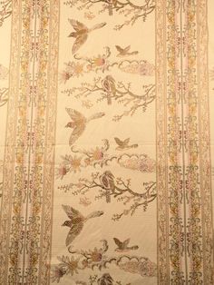 a wall hanging with birds and flowers on it