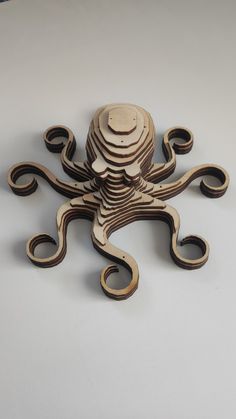 an octopus made out of wood on a white surface