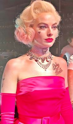 a woman in a pink dress with tattoos on her chest