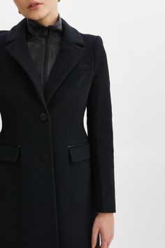 The Malva wool coat marries the best of polished glamour and feminine flair. The structured wool offers refined texture, while the semi-fitted hourglass silhouette offers a flattering fit. Elegant extras — like a removable leather bib, notched collar and flap pockets — also play a starring role. Shoulder pads add structure and the single-breasted, button-down design conveys timelessness. Black Removable inner leather dickie with zipper Single breasted button closure Notched collar Shoulder pads Elegant Fall Outerwear With Pressed Crease, Elegant Structured Outerwear With Lapel Collar, Elegant Tailored Structured Outerwear, Elegant Structured Office Outerwear, Timeless Wool Coat With Concealed Placket For Work, Fitted Wool Coat With Concealed Placket, Timeless Wool Coat For Work With Concealed Placket, Chic Wool Coat With Concealed Front For Office, Elegant Notch Lapel Outerwear For Career