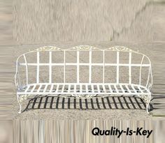 a white metal bench sitting on top of a cement ground