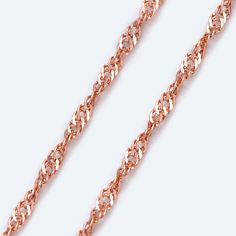 a rose gold chain on a white background