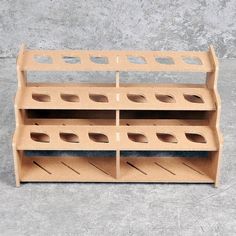 a wooden shelf with holes in the middle on concrete floor next to cement slabs