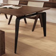 a wooden table with two chairs and a book on it